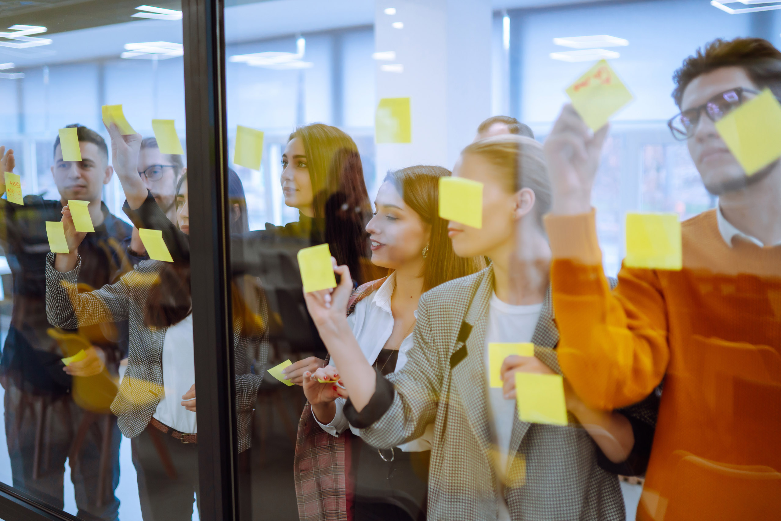 Sharing,Ideas,Concepts,With,Papernote,Writing,Strategy,On,Wall,Glass